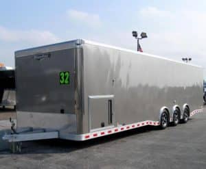 32' aluminum enclosed car trailer with triple spread axles and a generator door