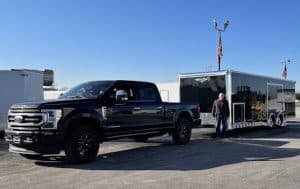 Black truck and enclosed trailer hitched up.