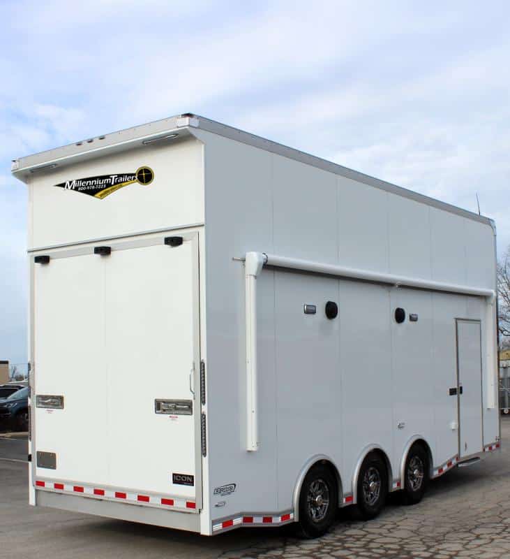 Stacker Trailer 2024 24' Aluminum Icon Performance Rear Curbside View. This features an electric awning, speakers, LED lights, side door, aluminum wheels, rear wing, & rear ramp door.