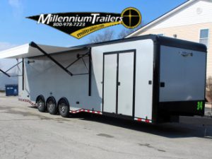 Enclosed Car Hauler 2024 34' Edge Front Curbside View. It features extended electric awning, silver bonded exterior, electric tongue jack, & aluminum wheels.