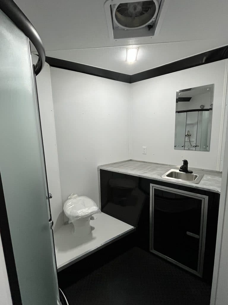 Bathroom with toilet, sink, and vent fan.